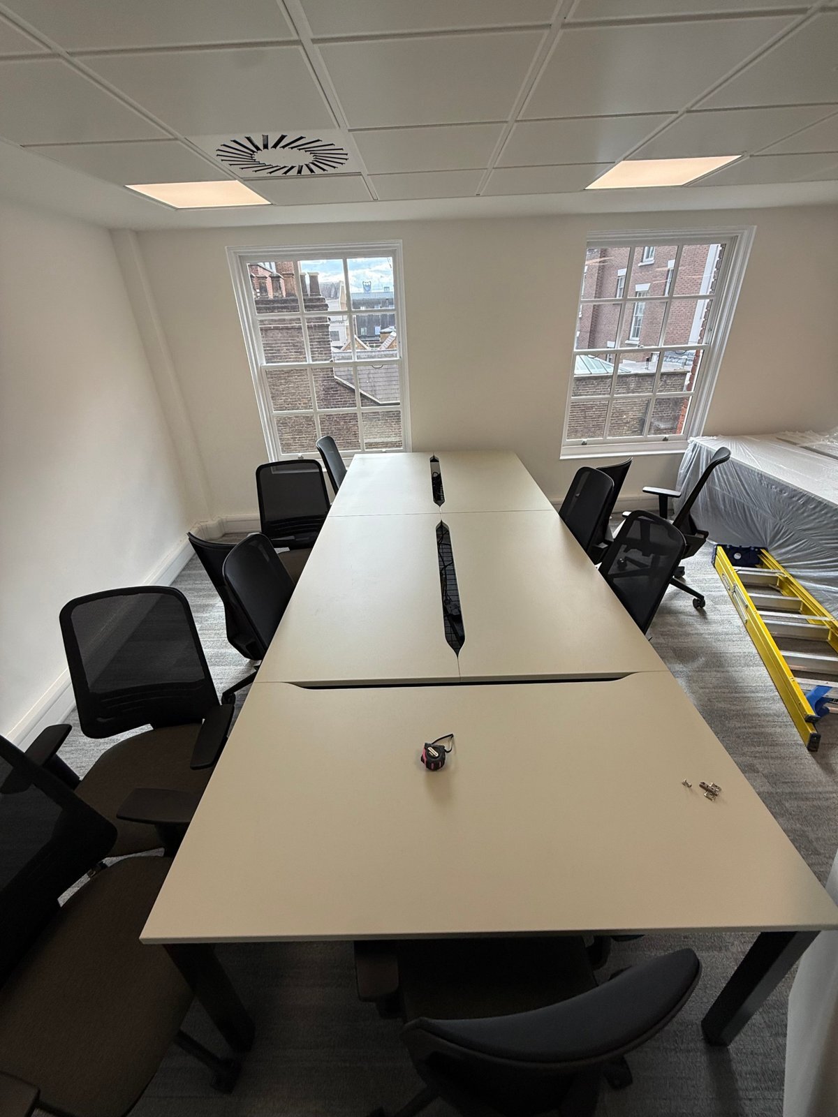 Empty bench desks with curved cable cut-outs at Totum Partners, Cannon Street, before the desk screens were fitted